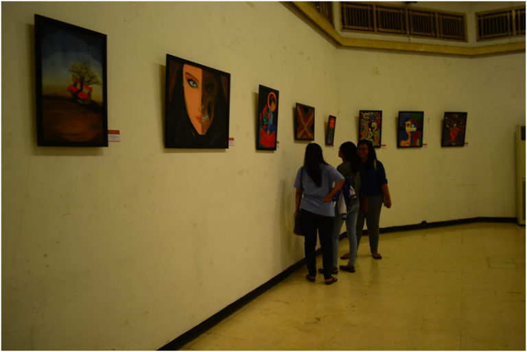 Pengunjung menikmati lukisan yang ada di pameran TITIK AWAL #2 : Kaki Kiri Tangan Kanan.