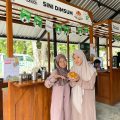 Nirisa Afni Naila Muazara (kiri) bersama partner bisnisnya menunjukkan produk Sini Dimsum di stand Z-Corner, Universitas Sebelas Maret pada Kamis (18/12/2025). LPM Kentingan/Zulfi Khoirunisa