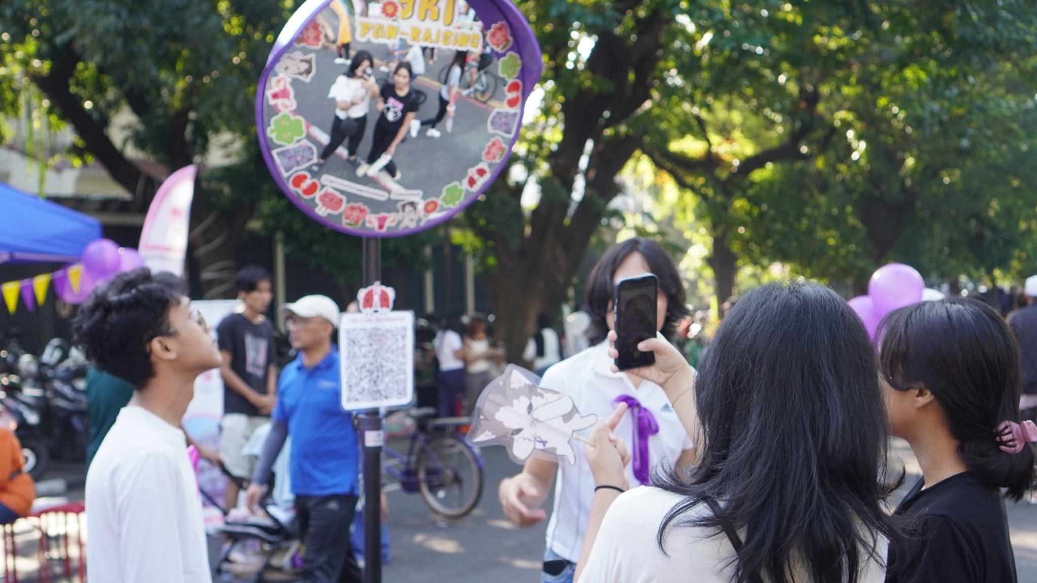 Pengunjung berswafoto melalui convex mirror yang telah disediakan oleh panitia sebagai salah satu cara kreatif dalam penggalangan dana. Foto: Dok. Panitia YKI Fun-raising Day